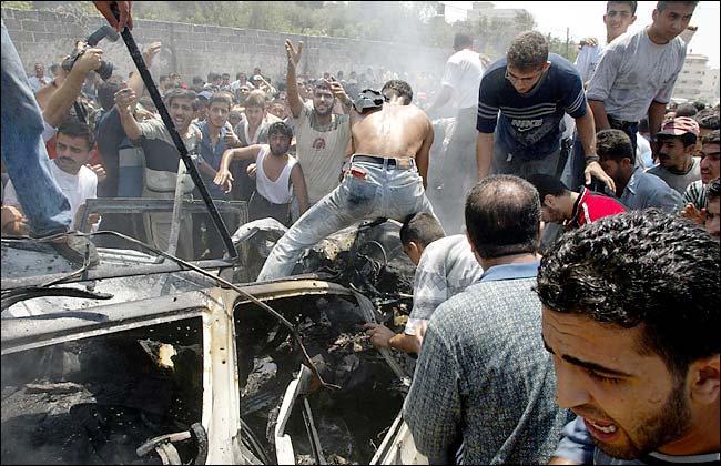 Palestinians pulled bodies from a car carrying a Hamas political leader Ismael Abu-Shanab after it was attacked by Israeli missiles, Gaza, August 21, 2003.