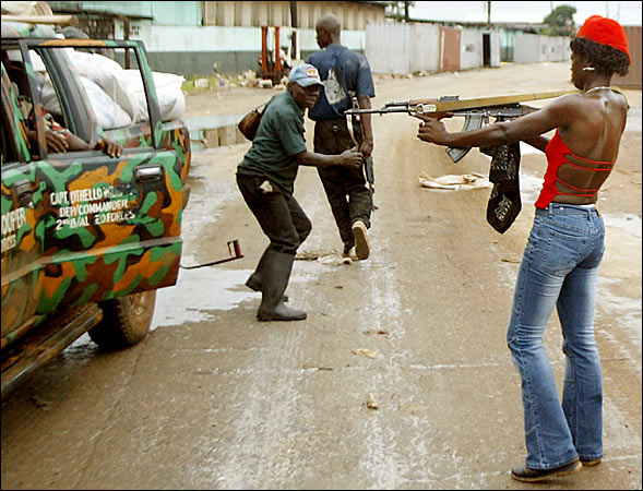 A woman fighting with rebel forces chased looters who were stealing supplies from the port in Monrovia, Liberia, August20, 2003.