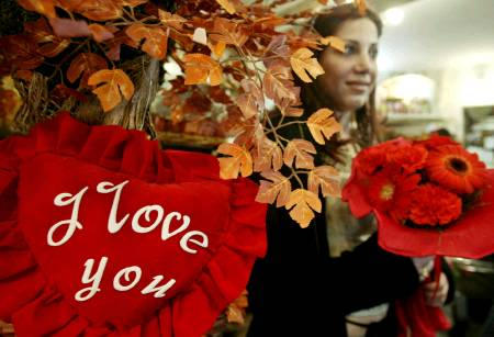 A Muslim Iraqi woman holds a bouquet of flowers in a souvenir shop on Valentine Day, central Baghdad, February 14, 2004.