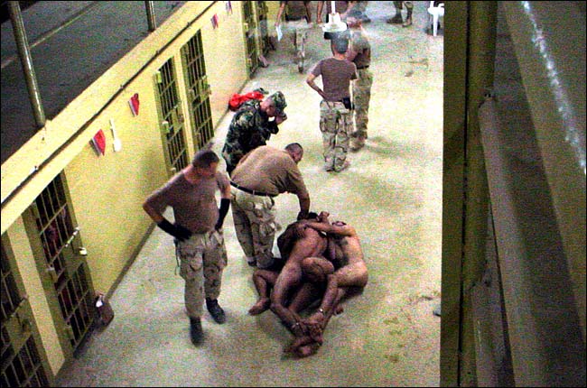 A group of men lie naked and bound to one another on the walkway in front of the cells, Abu Ghraib prison, Baghdad, in this undated photo published in The Washington Post on May 6, 2004.