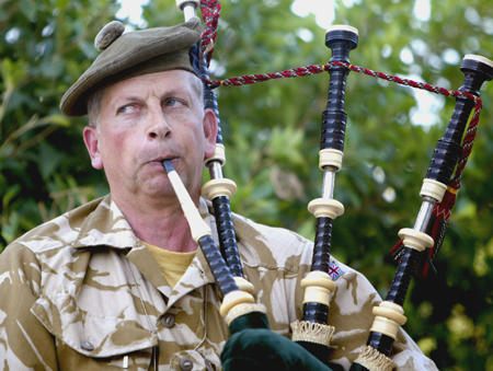 A British Fusilier plays a bagpipe during a flag raising ceremony on the embassy grounds welcoming Britain's first ambassador to Baghdad in 13 years, July 7, 2004.