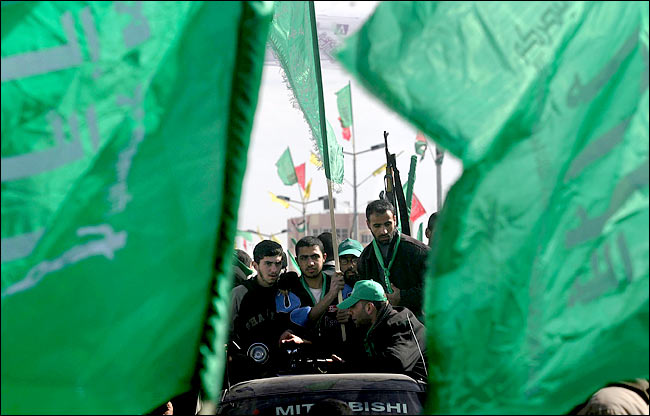 After winning elections, Palestinian supporters of Islamic Hamas wave flags and hold weapons during a rally in the southern Gaza Strip refugee camp of Khan Younis, January 26, 2006.