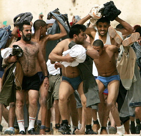 Palestinians who stripped in response to Israeli orders tumble out of a jail compound, Jericho, March 14, 2006.