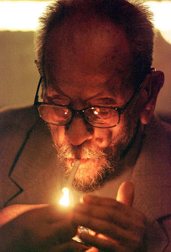 Egyptian author and Nobel laureate Naguib Mahfouz lights a cigarette, November 19, 2002.