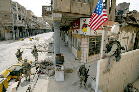 An American soldier raised the flag at a checkpoint near the National Bank, Baghdad, April 18, 2003.