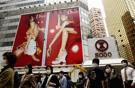 Pedestrians wearing surgical masks, as a precaution against a mysterious unusual type of pneumonia called SARS, downtown Hong Kong, April 9, 2003.