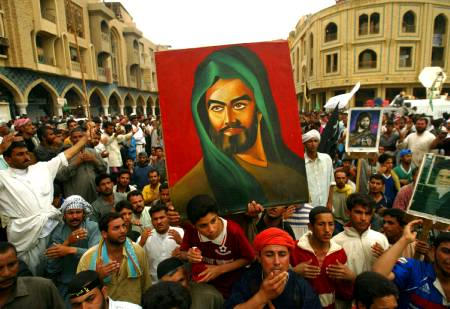 Iraqi Shi'ite men carry an portrait of Imam Ali as they beat their chests around the holy shrine in the center of Karbala, April 21, 2003. Iraqi Shi'ite Muslims travelled to the holy city of Kerbala to commemorate the 40th day after the death of Imam Hussein, the grandson of the Prophet Mohammed, over 1,400 years ago.