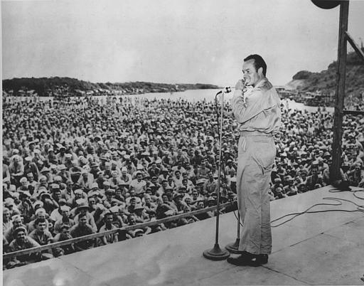 Bob Hope entertains a large crowd of American servicemen during World War II, airstrip in Munda, New Georgia, the Pacific Ocean, October 31, 1944.
