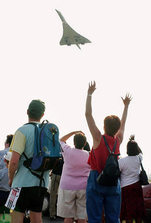 Concorde fans wave at the Air France plane before it lands at Paris Roissy airport after its final commercial flight from New York, May 31, 2003.