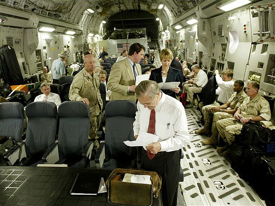 Defense Secretary Donald Rumsfeld looks over some papers as he and his entourage wait to take off from Saudi Arabia after a seven-hour stop, April 29, 2003.