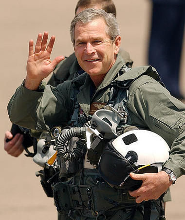 President Bush waves as he walks on the tarmac to a Navy S-3B Viking plane at North Island Naval Station in Coronado, California, May 1, 2003.