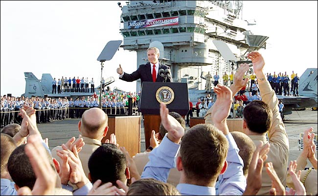 President George W. Bush flashes a thumbs-up after declaring the end of major combat in Iraq, aboard the aircraft carrier USS Abraham Lincoln, off the California coast, May 1, 2003.