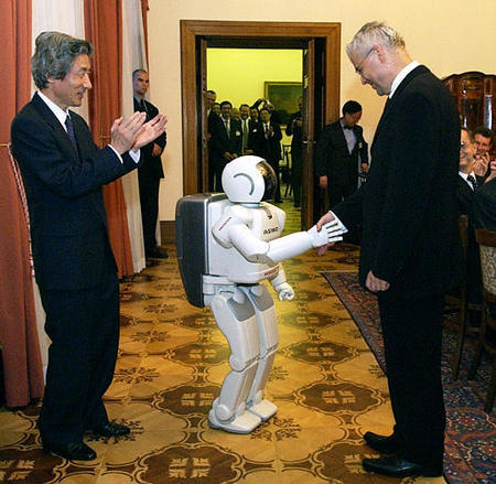 Japanese Prime Minister Junichiro Koizumi applauds while his Czech counterpart Vladimir Spidla shakes hands with the humanoid robot Asimo Honda presented by Koizumi, Hrzansky Palace, Prague, August 21, 2003.