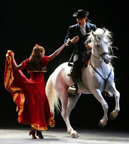 Dancer Lalo Tejada dances with a Spanish thoroughbred ridden by an Andalusian rider during the Andalusian Opera 'Carmen' with horses, bugles and drums, Seville, September 4, 2003.