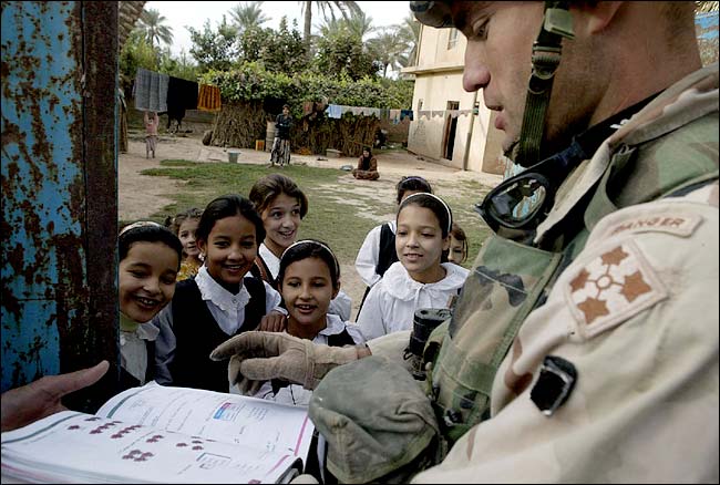 Captain Todd Brown takes part in an impromptu English class with local children following a raid on neighborhood homes, Balad, Iraq, November 1, 2003.