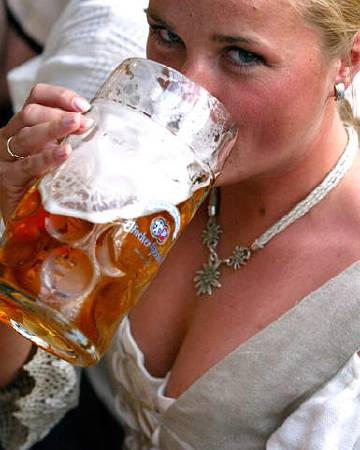 Daniela Braml, wearing a traditional Bavarian dirndl (dress) drinking beer at Munich's Oktoberfest beer festival, October 2003.