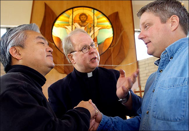 The Rev. Canon James Newman of St. Bede's Episcopal Church with Jusak Y. Bernhard, left, and Jeffrey A. Manley, going through the steps of celebrating their union,  Los Angeles, January 2004.