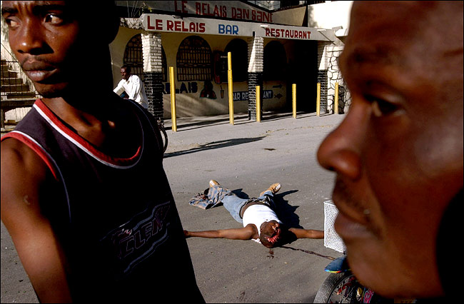 A Haitian killed by supporters of President Jean-Bertrand Aristide was left in a street in Saint-Marc, 45 miles west of capital Port-au-Prince, Haiti, February 9, 2004.