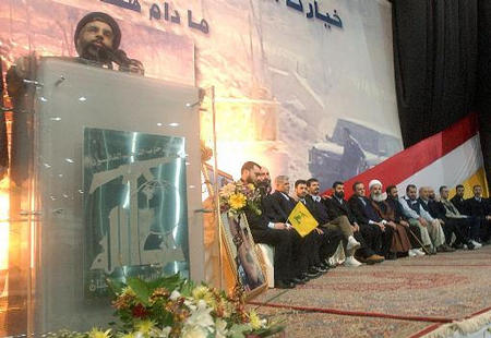 Hezbollah leader Hassan Nasrallah speaks, as the Lebanese prisoners who were released from Israel sit to the right of him on the podium during a mass rally to welcome 21 Lebanese prisoners freed by Israel, a suburb of southern Beirut, Lebanon, January 29, 2004.