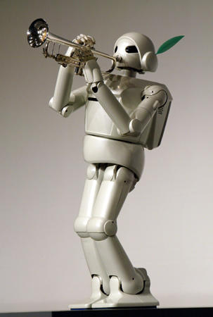 Toyota's humanoid walking robot plays the trumpet as it makes a debut before reporters, Tokyo, March 11, 2004.