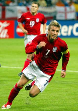 England's David Beckham celebrates after scoring a penalty against Argentina. Striker Michael Owen follows. June 7, 2002.