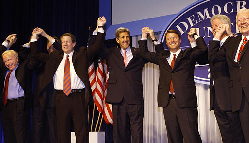 Democratic presidential candidate Senator John Kerry, D-Mass., center, raises hands with fellow Democrats, from left, Sen. Joe Lieberman, D-Conn., former Vice President Al Gore, Sen. John Edwards, D-N.C., former President Bill Clinton and former President Jimmy Carter during a Democratic National Committee Unity Dinner, the National Building Museum, Washington, March 25, 2004.
