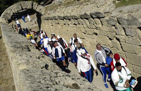 Olympic men's shot-put finalists walk through the same stone archway as athletes did in 776 B.C., to the ancient site of the Olympics, used for Olympic competition for the first time in nearly 16 centuries, in the 2004 Athens Olympic Games, Ancient Olympia, Greece, August 18, 2004.