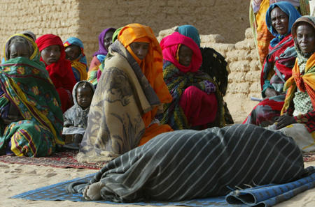 Sudanese refugee black African women who are fleeing their Arab government bombing campaign on Darfur, wait near a sick woman at a hospital run by Medecins Sans Frontieres (Doctors without Borders), Tin, Chad, January 26, 2004.