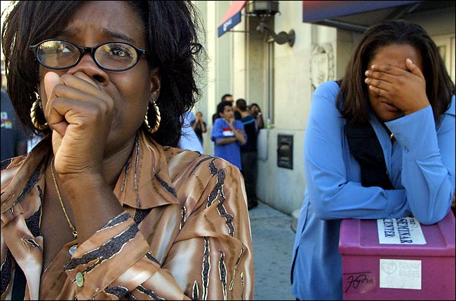 The iconic image by Angel Franco of the New York Times of onlookers watch in horror or turn away as the south tower collapses (seen reflected in one woman's glasses), New York, September 11, 2001 09:59 AM.