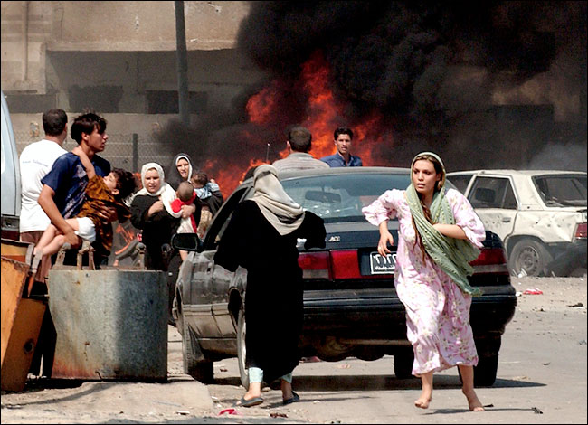 Iraqis fled the scene after car bomb explosions at a street celebration of the opening of a sewage plant where two bombers drove their cars into crowds of children waiting to receive candy from G.I.'s, Baghdad, September 30, 2004