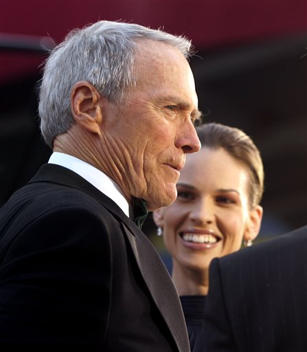 Clint Eastwood is interviewed on the red carpet as Hilary Swank looks on as they arrive to the 77th annual Academy Awards show (later both win for their work in Million Dollar Baby as director and producer and as actress), Los Angeles, February 27, 2005.