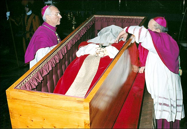 Archbishop Stanislaw Dziwisz places a veil over Pope John Paul II's face before the public funeral Mass at the Vatican, April 8, 2005.