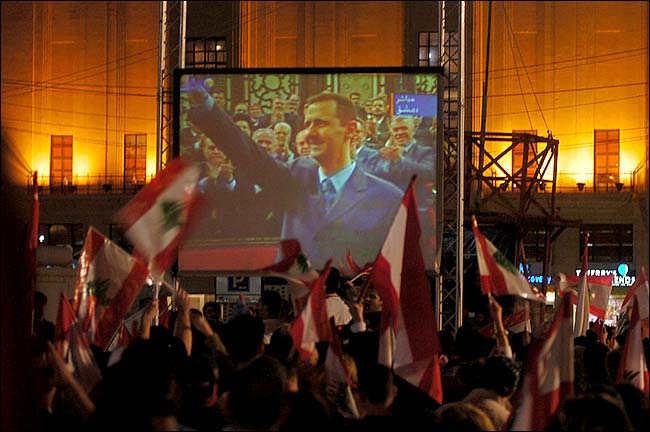 Thousands gathered to watch on giant screens President Bashar al-Asad of Syria declaring withdrawal of his troops from Lebanon, Beirut, March 5, 2005.