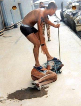 A detail of an undated handout photograph, issued on January 18, 2005, that has been used as evidence in a court martial in Osnabrueck, Germany of British soldiers accused of abusing Iraqi prisoners, purporting to show Lance corporal Darren Larkin standing on an Iraqi detainee and corporal Daniel Kenyon taking a photograph in the rear.