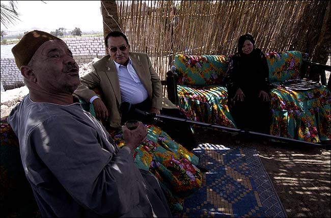 Mahmoud Fathy, a retired government worker, recites a poem to Mr. Mubarak as Mr. Fathy's wife, Saadia Abdul Hakim, listens, Minya, Egypt, August 25, 2005.