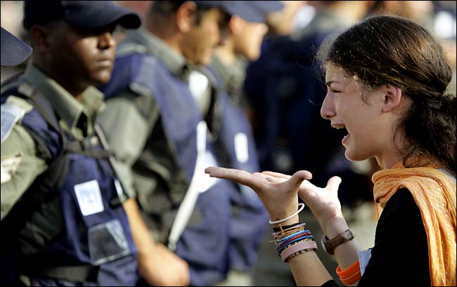 An Israeli settler confronts a line of police after they surrounded a synagogue in Neve Dekalim, Gaza, August 18, 2005.