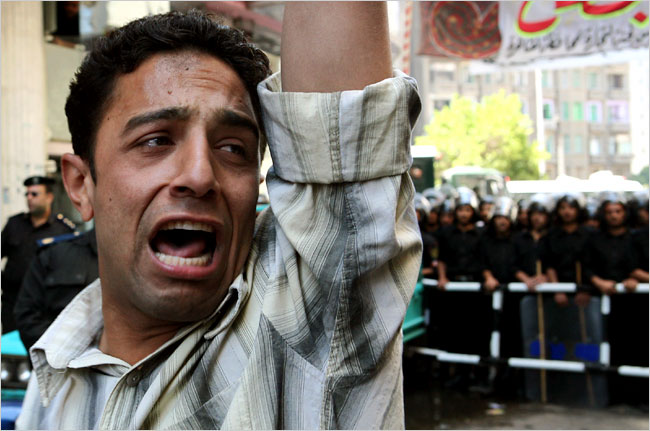 A protester cries in front of Egyptian riot police during a protest showing support for Islamist judges, Cairo, Egypt, May 11, 2006.