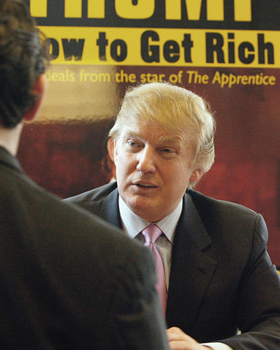 Donald Trump, who is on hand to promote his new book 'How to Get Rich,' speaks to a man at a book retailer in New York, March 24, 2004.