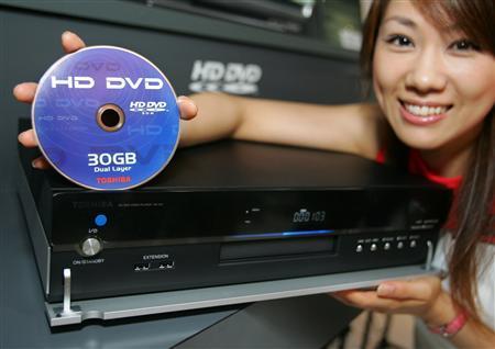 A model presents Toshiba Corps prototype HD DVD player and HD DVD-ROM discs at a technology trade exhibition, in Makuhari, east of Tokyo, October 4, 2005.