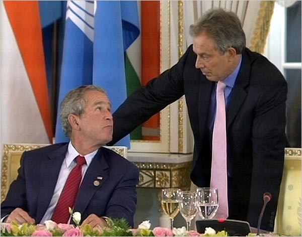 U.S. President George W. Bush shares a private word with British Prime Minister Tony Blair, during working lunch at the G8 summit, St. Petersburg, Russia, July 17, 2006.