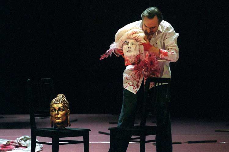 In one scene of Mozart's opera 'Idomeneo,' the King of Crete, here played by Charles Workmann in a 2003 rehearsal, handles the severed heads of Poseidon, Buddha (on the left), Jesus Christ and Muhammad (already in his hands).