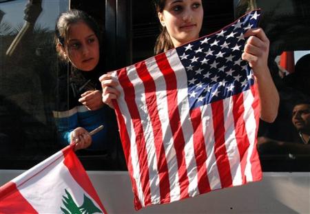 Two Lebanese girls hold the American and the Lebanese flags in a bus heading to Martyrs' Square where mourners gather before the funeral of assassinated Christian politician Pierre Gumayel, Beirut, Lebanon, November 23, 2006.