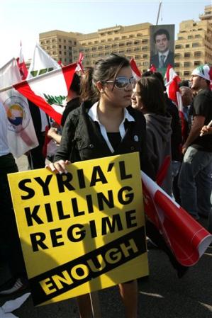 A Lebanese girl holds a placard where mourners are gathered in Martyrs' square before the funeral of assassinated Christian politician Pierre Gumayel, Beirut, Lebanon, November 23, 2006.