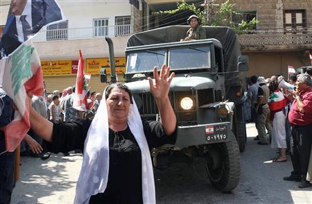 A Lebanese woman dances in front of an army truck during its arrival at Shebaa village in south Lebanon, August 18,2006.