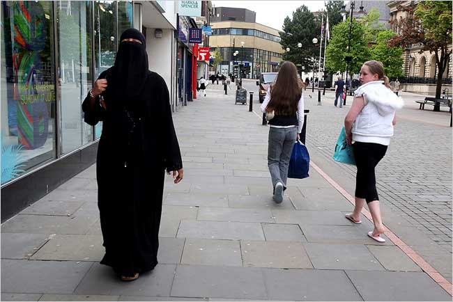 A woman identified only as Ms. Mayata walks through one of London streets, only to be stopped and asked ‘Why do you wear that?' or receive other rude comments about her niqab, London, June 2007.