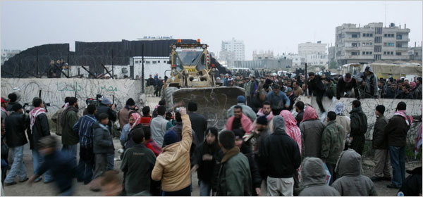 Palestinians use explosives and bulldozers to open as many as 15 holes along the fence in their new invasion of Egypt, January 23, 2008.