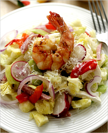 The signature garbage salad for heavy drinkers is a cocktail party in a bowl, salami, mozzarella, shrimp with enough iceberg and celery to keep it all crunching.