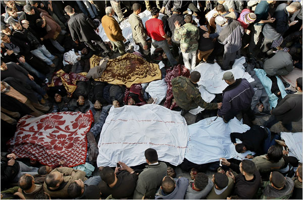 Palestinians gather around bodies being removed from the site of an airstrike as hundreds of Palestinians are killed and scores more wounded in the first hour of Israels massive attack on about 100 Hamas sites throughout Gaza in retaliation for the recent rocket fire from the area, Gaza, December 27, 2008.
