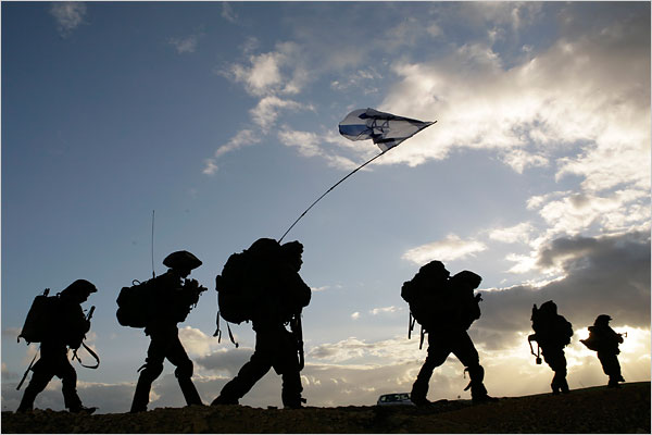 Israeli soldiers hold their country's flag as they head back to Israel, January 18, 2009.
