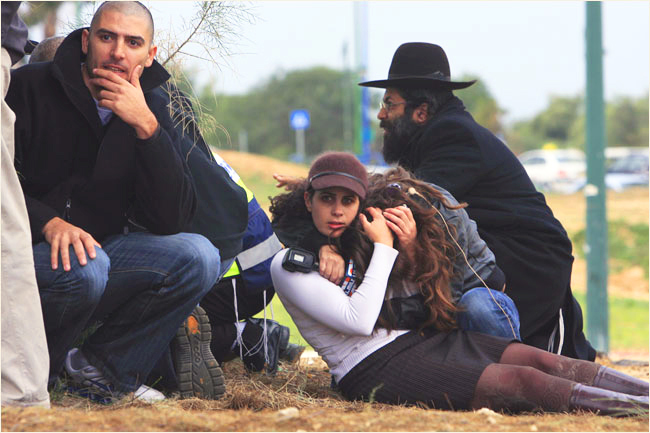 On the third day of Israels massive attack on Hamas sites throughout Gaza in retaliation for the recent rocket fire from the area, Israelis take cover during a rocket warning siren in the southern Israeli town of Ashkelon, where a rocket fired from Gaza killed an Arab man and wounded seven this day, December 29, 2008.